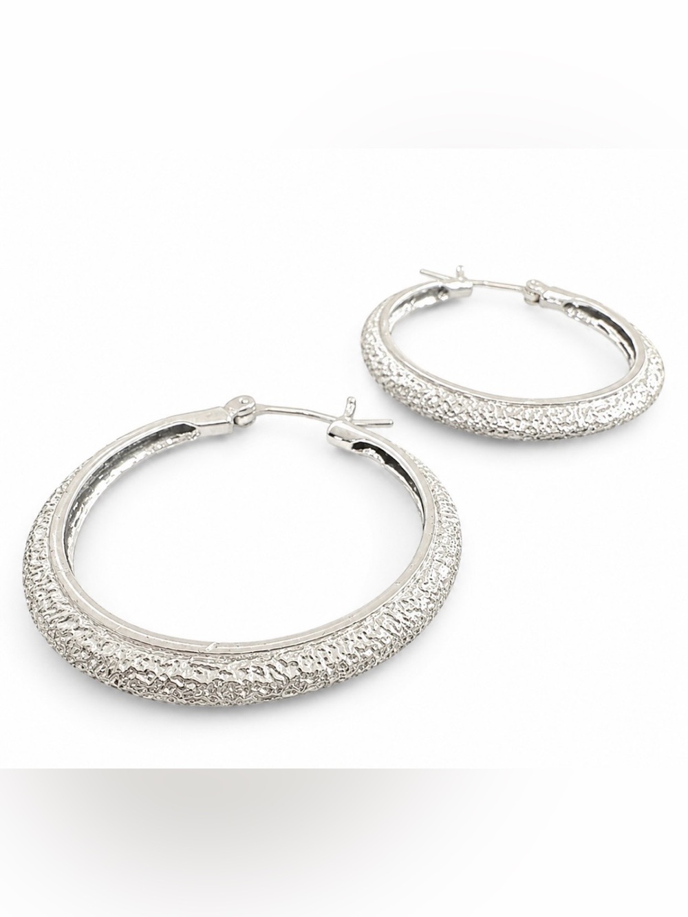 Silver-toned hoop earrings with textured sparkle finish surface.